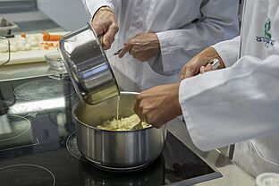 Groupe d'étudiantes en Diététique dans la cuisine pédagogique de l'IUT, préparant des plats sur les paillasses en inox.