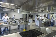 Groupe d'étudiantes en Diététique dans la cuisine pédagogique de l'IUT, préparant des plats sur les paillasses en inox.